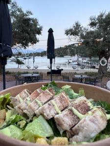 梅加尼西岛Amphitheatro Boutique Hotel的上面有一碗沙拉和金枪鱼三明治
