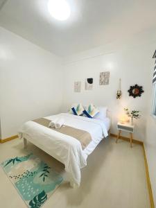 莫阿尔博阿Sunset Paradise Moalboal的白色卧室配有床和桌子