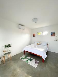 莫阿尔博阿Sunset Paradise Moalboal的一间白色卧室,配有床和地毯
