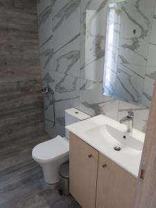 拉扎克利翁blue view sea apartment的浴室配有白色卫生间和盥洗盆。