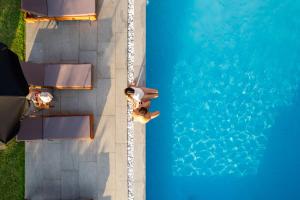 帕拉利亚卡泰里尼斯亚金特霍斯公寓式酒店的游泳池的顶部景色,有一个人站在游泳池旁