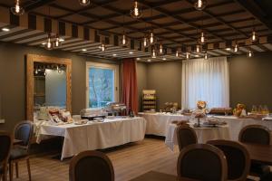 皮索涅Lake Hotel La Pieve的宴会厅配有带白色桌布的桌子