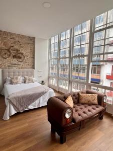费罗尔Hostal Zahara的一间卧室配有一张床、一张沙发和窗户。