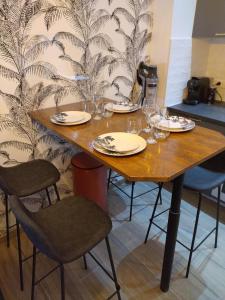 库尔瑟勒·苏尔·梅尔Le triplex Côté plage plein Sud的一张木桌,配有椅子和盘子,酒杯