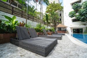 芭东海滩Patong Central Residence and Apartment的游泳池旁的一排柳条椅
