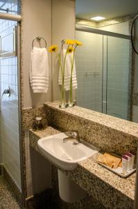 贝洛奥里藏特萨瓦西皇家精品酒店的浴室设有水槽和黄色花瓶
