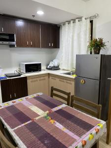 大雅台Alitheia Condo @ Pine Suites Tagaytay的厨房配有桌子和冰箱