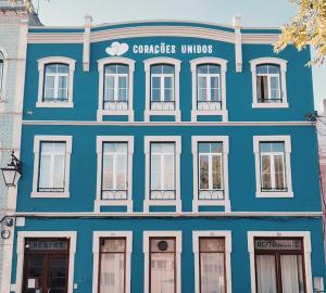 阿尔科巴萨Corações Unidos "A Pensão"的蓝色的建筑,在街上有白色的窗户