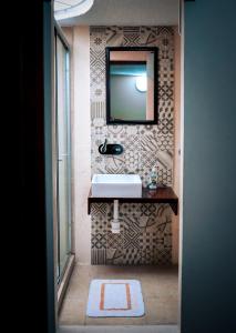 墨西哥城Suites Cuija Coyoacan的浴室设有水槽和墙上的镜子