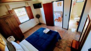 蒂拉登特斯Pouso de Santana的一间设有蓝色床的客房和一间带浴室的客房