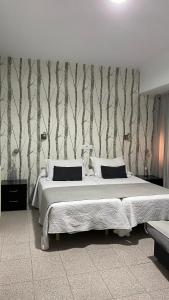 普拉森西亚林孔埃斯特雷马杜拉酒店的一间卧室设有一张床,墙上有树木