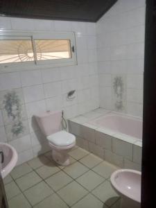 杜阿拉Grace and favour guest house的浴室配有卫生间、浴缸和水槽。
