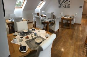 因弗内斯德鲁伊住宿加早餐旅馆的用餐室配有木桌和白色椅子