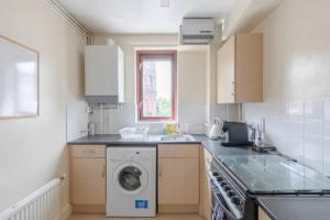 伦敦Bright & Calming 1BD Flat - Islington的厨房配有洗衣机和水槽
