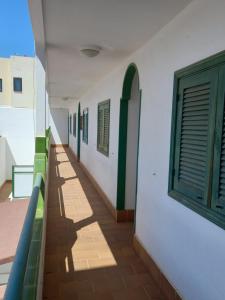 科拉雷侯Las Islas Apartment的建筑的走廊,设有绿色的窗户