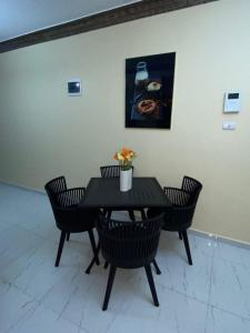 圣地亚哥洛斯卡巴Acogedor Apartamento的一张带椅子的黑桌和墙上的照片