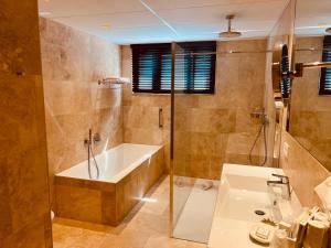 布兰肯贝赫Gatsby Hotel - Adults Only - Small Luxury Hotel - by F-Hotels的带浴缸和盥洗盆的浴室