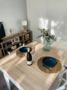 第戎Appartement cosy的一张桌子,上面放两个盘子和一瓶葡萄酒