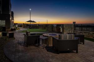 Sunrise AcresTownePlace Suites El Paso North的庭院配有桌椅和遮阳伞。