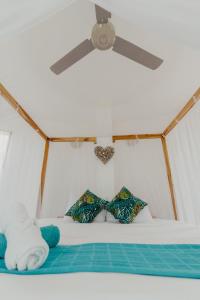 帕洛米诺UUTTAAKA Eco-Hotel的一间卧室配有吊扇和一张带枕头的床。
