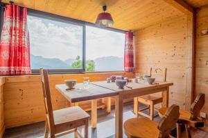 于埃Apartment with a superb view in l'Alpe d'Huez - Welkeys的一间带桌椅和大窗户的用餐室