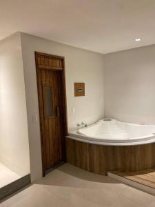 里约热内卢Verona Hotel的木门的客房内设有一个大浴缸