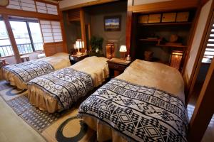 佐渡市Natural Mind Tour guest house - Vacation STAY 23273v的一间房间,有三张床