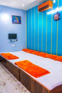 乌贾因Mangal kripa homestay的一间卧室配有两张带橙色床单的床