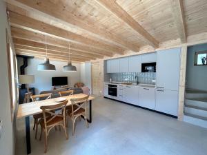 贝尔维尔德赛当亚CAL GALL rural Cerdanya的一间厨房和带木制天花板的用餐室