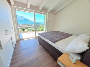 多马索Immobillario - Lakes Dream的一间卧室设有一张床和一个大窗户