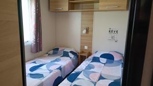 阿旺桥Mobil home 3 ch domaine de kerlann pont aven wifi inclu的两张睡床彼此相邻,位于一个房间里