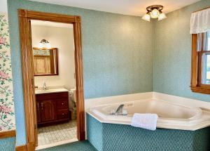 新肖雷汉姆Rose Farm Inn的带浴缸和盥洗盆的浴室