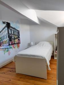 波尔图OLOPO的卧室配有白色的床和墙上的绘画作品