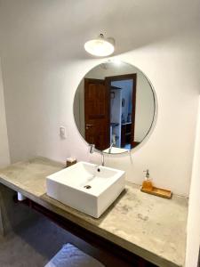 卡姆布库Controvento Boutique Hotel的浴室设有白色水槽和镜子