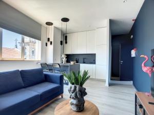 欧瓦O Flamingo Apartments的客厅配有蓝色的沙发和桌子