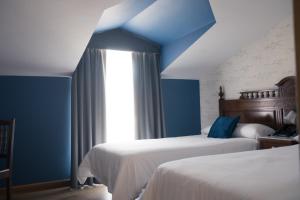 Viveda雀利酒店的一间卧室设有两张床和蓝色的天花板