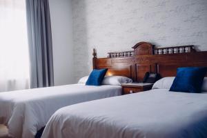 Viveda雀利酒店的两张带蓝色枕头的床