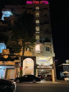 土龙木市SAO BĂNG HOTEL的停在大楼前的一辆黑色汽车