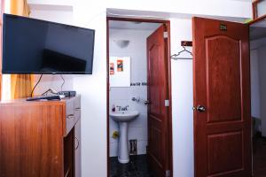 库斯科Casa de Laura的一间带电视、水槽和卫生间的浴室