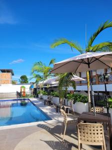 圣奥古斯丁Hotel Gran Plaza San Agustin的一个带游泳池、椅子和遮阳伞的度假村