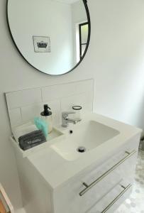 惠灵顿Studio 9 on Lakewood的白色浴室水槽,上面有镜子