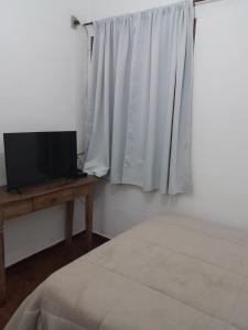 蒂拉登特斯POUSADA PARLATORIUM的一间卧室配有一张床、一台电视和一个窗口