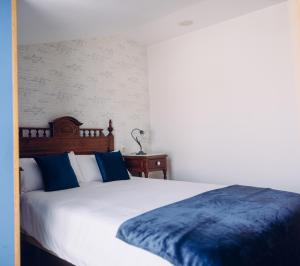 Viveda雀利酒店的一间卧室配有白色床和蓝色枕头
