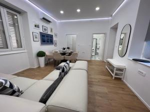 皮兰Grand Apartment Piran的客厅配有白色的沙发和桌子