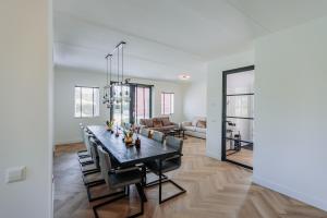 阿姆斯特丹Brand new bright luxurious villa in Amsterdam!的用餐室以及带桌椅的起居室。