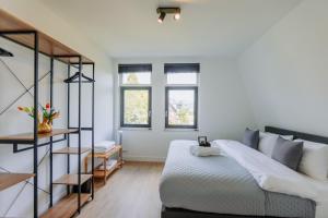 阿姆斯特丹Brand new bright luxurious villa in Amsterdam!的卧室配有床、楼梯和窗户。
