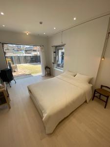 庆州Maison de Clare的卧室设有一张白色大床和一扇窗户。
