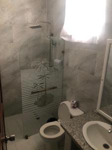 纳瓜坎布里酒店的带淋浴、卫生间和盥洗盆的浴室