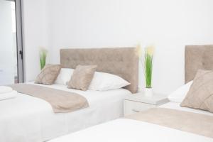 乌尔齐尼NESI Apartments的卧室设有2张床和白色的墙壁。
