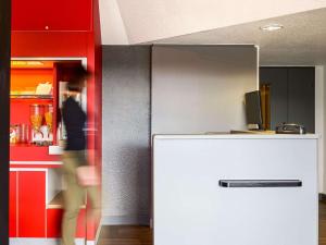 博韦博韦F1酒店的一间设有白色冰箱和红色橱柜的客房